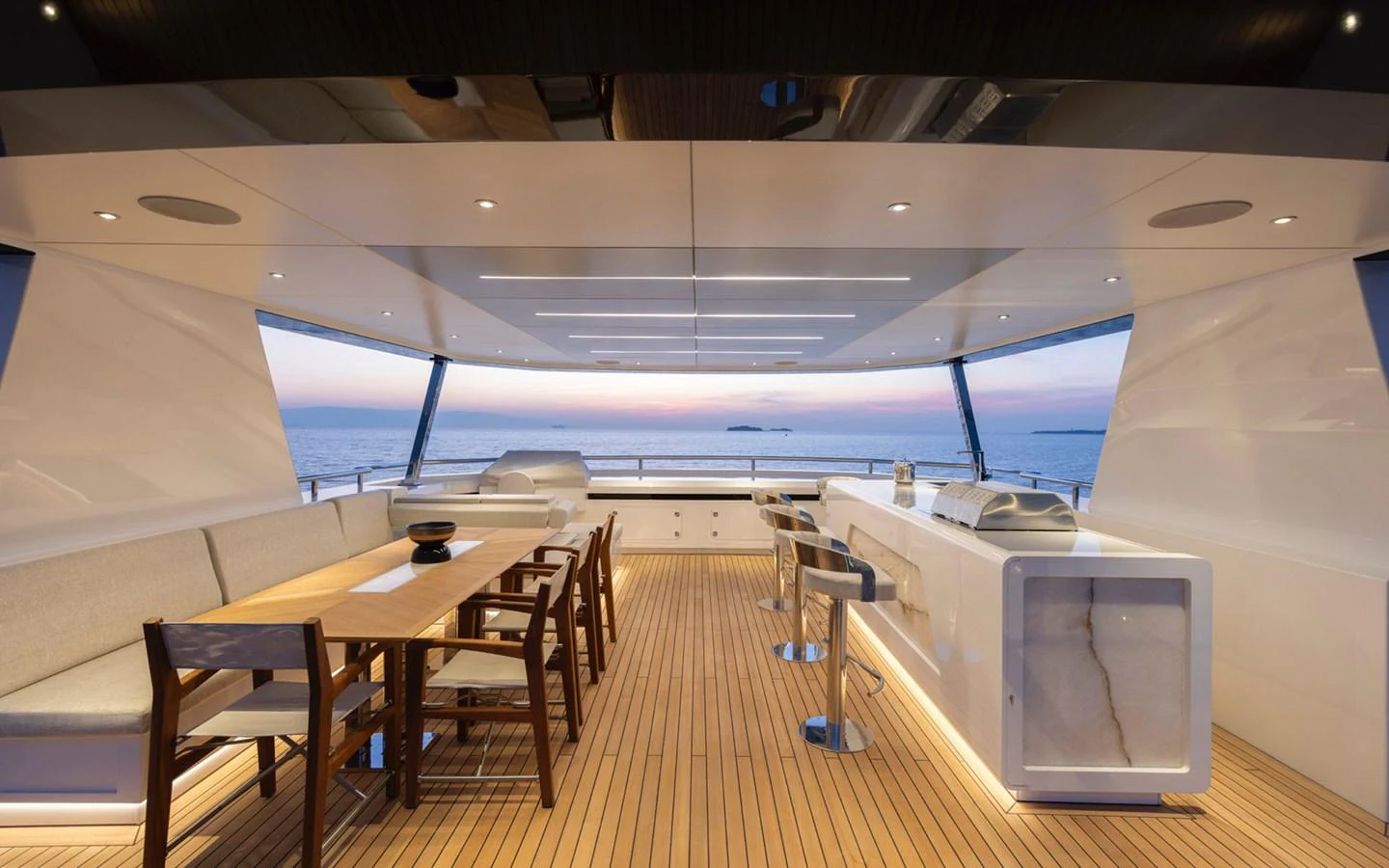 An elegant aft deck with a dining area and bar, offering stunning sea views. aboard BEE EXPLORER YACHT Yacht for Sale