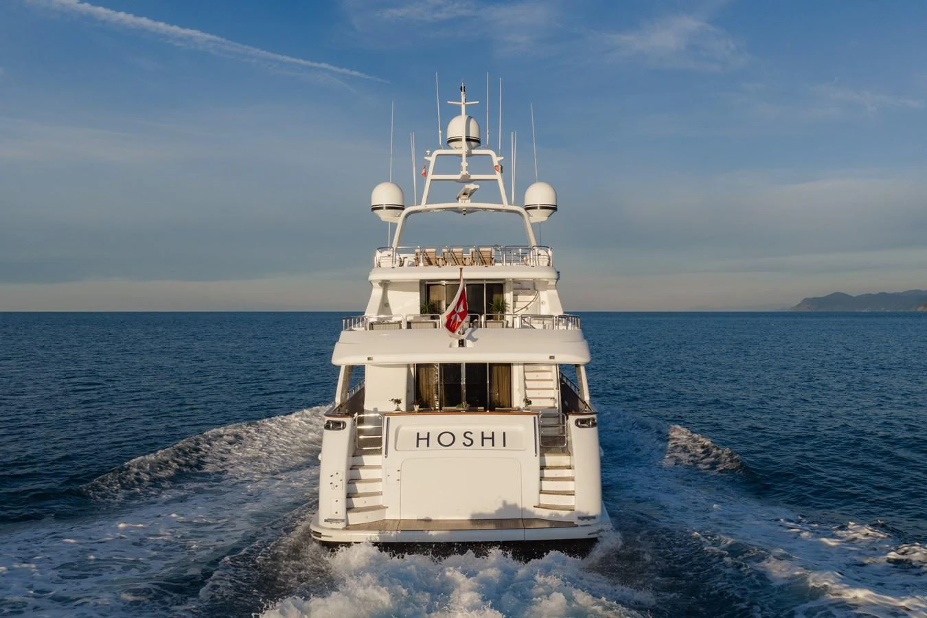 A luxurious yacht cruising on the open sea, showcasing its elegant design and spacious deck. aboard HOSHI Yacht for Sale