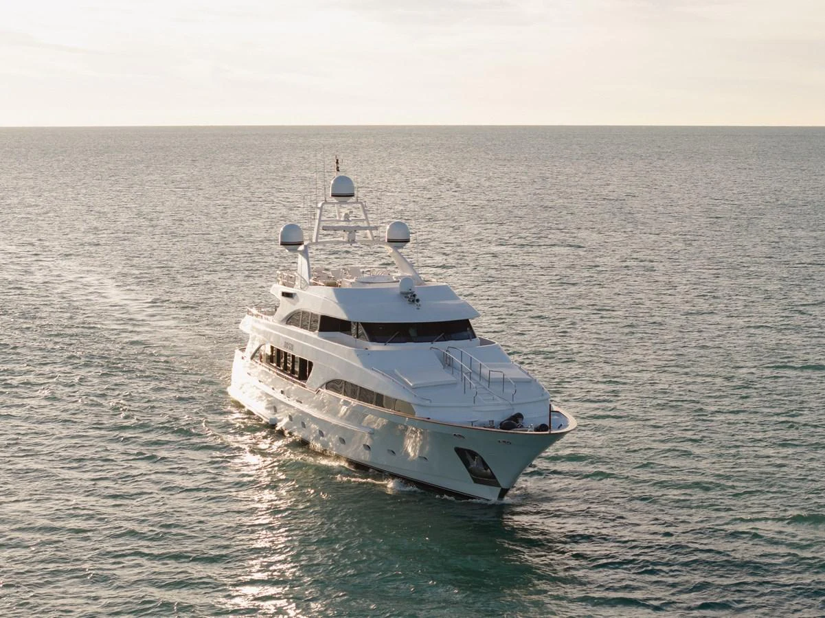 A luxurious yacht cruises gracefully on calm waters under a serene sky. aboard HOSHI Yacht for Sale