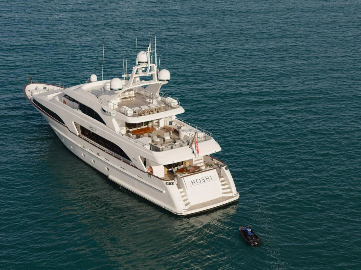 A luxurious yacht is anchored in calm waters, showcasing its elegant design and spacious decks. aboard HOSHI Yacht for Sale