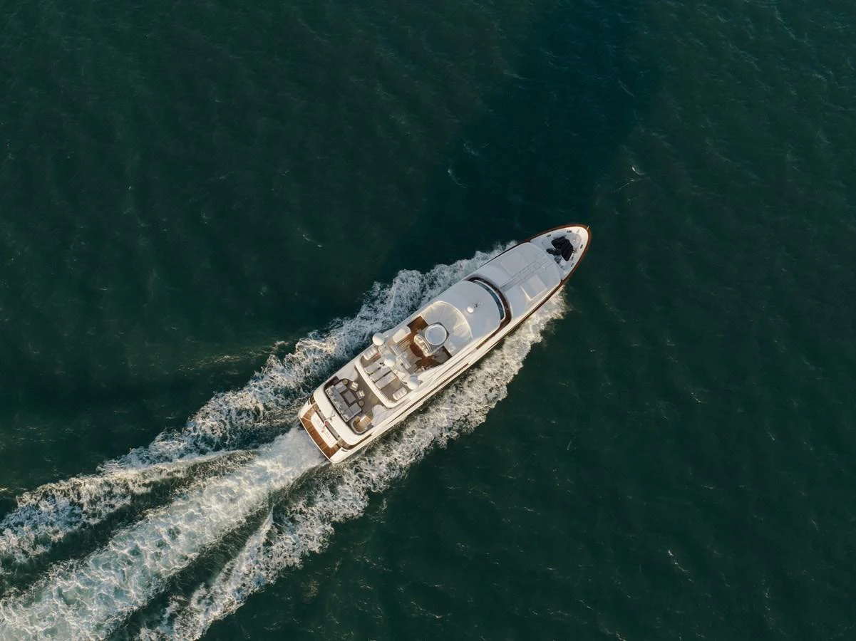 A sleek yacht cruises through the water, leaving a trail of white wake behind. aboard HOSHI Yacht for Sale
