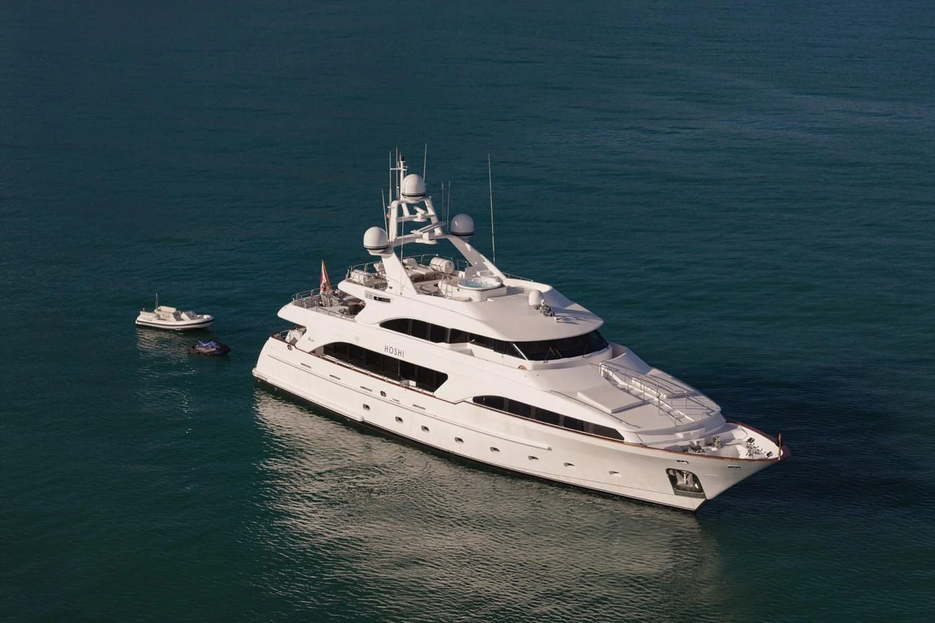 A luxurious yacht glides gracefully on calm waters, showcasing its elegant design and spacious decks. aboard HOSHI Yacht for Sale