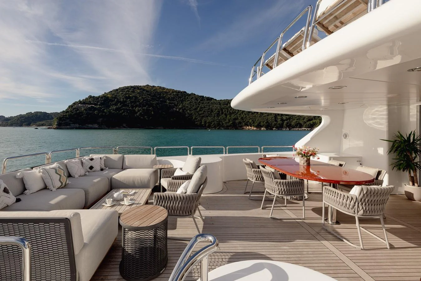 The aft deck features a spacious seating area with plush cushions and a dining table, perfect for alfresco dining and relaxation. aboard HOSHI Yacht for Sale