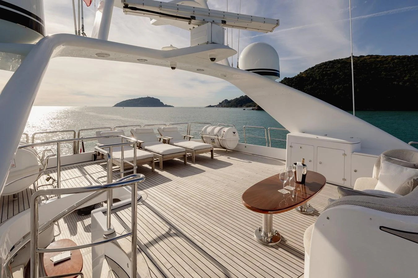 The sundeck offers a spacious area with lounge chairs and a table, perfect for relaxation and enjoying the view. aboard HOSHI Yacht for Sale