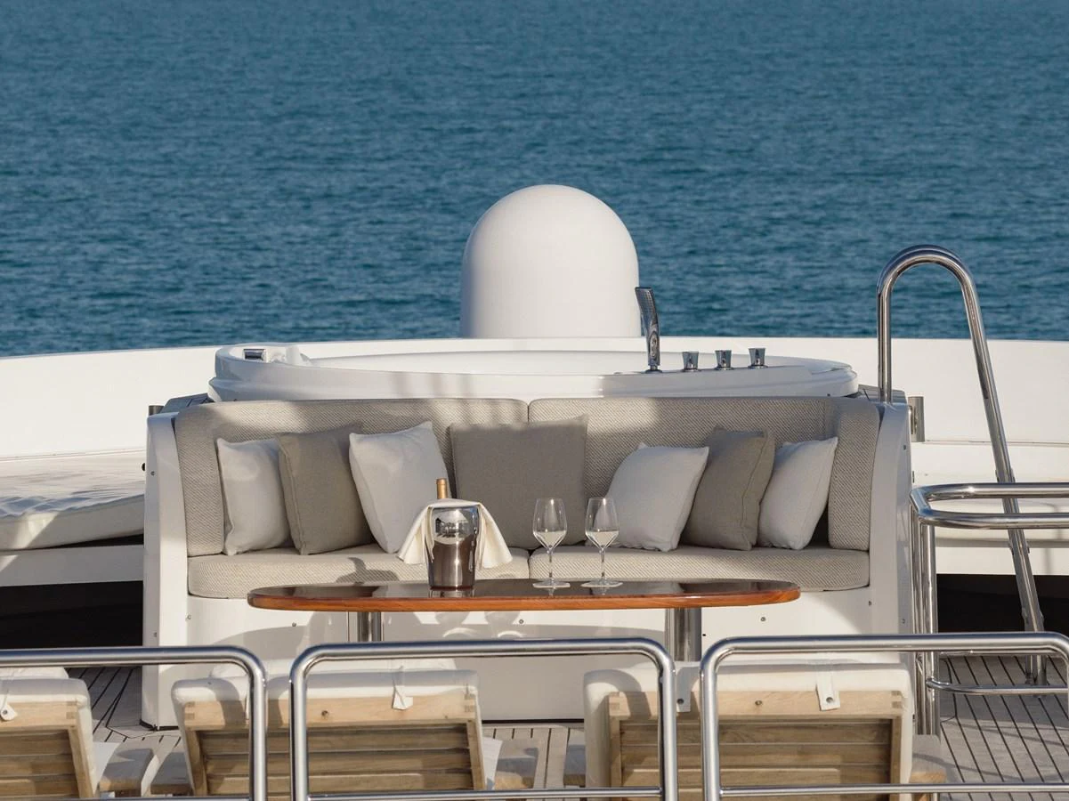 The sundeck features a luxurious jacuzzi with comfortable seating and a small table for refreshments. aboard HOSHI Yacht for Sale