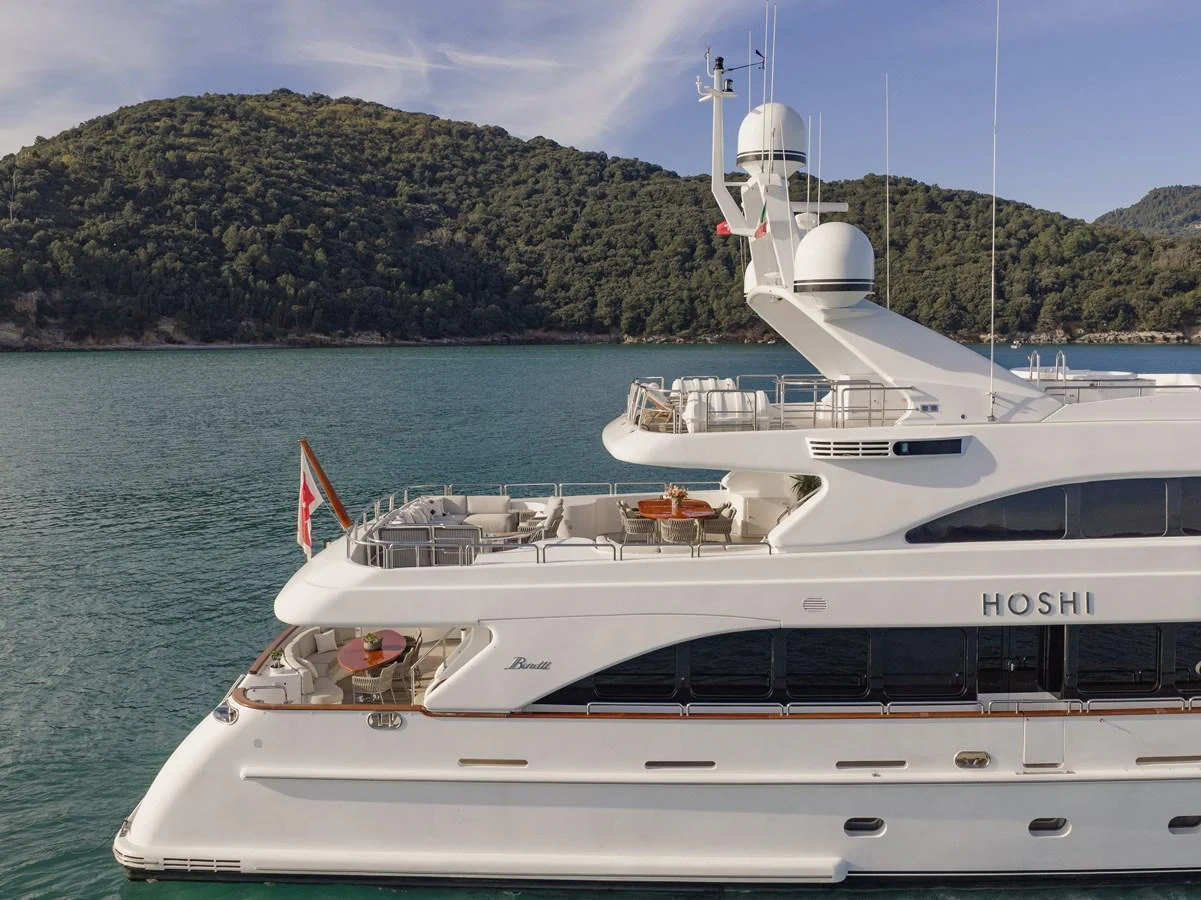 This luxurious yacht is anchored in a serene bay, showcasing its elegant design and spacious decks. aboard HOSHI Yacht for Sale