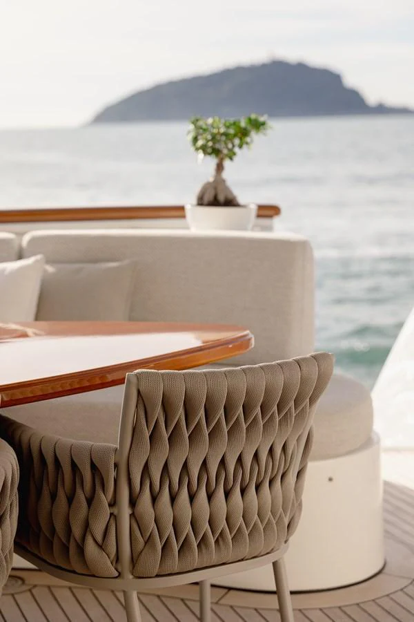 The aft deck features a stylish dining area with plush seating and a serene ocean view. aboard HOSHI Yacht for Sale