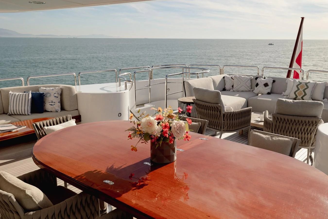 The aft deck offers a luxurious outdoor seating area with a stunning ocean view. aboard HOSHI Yacht for Sale