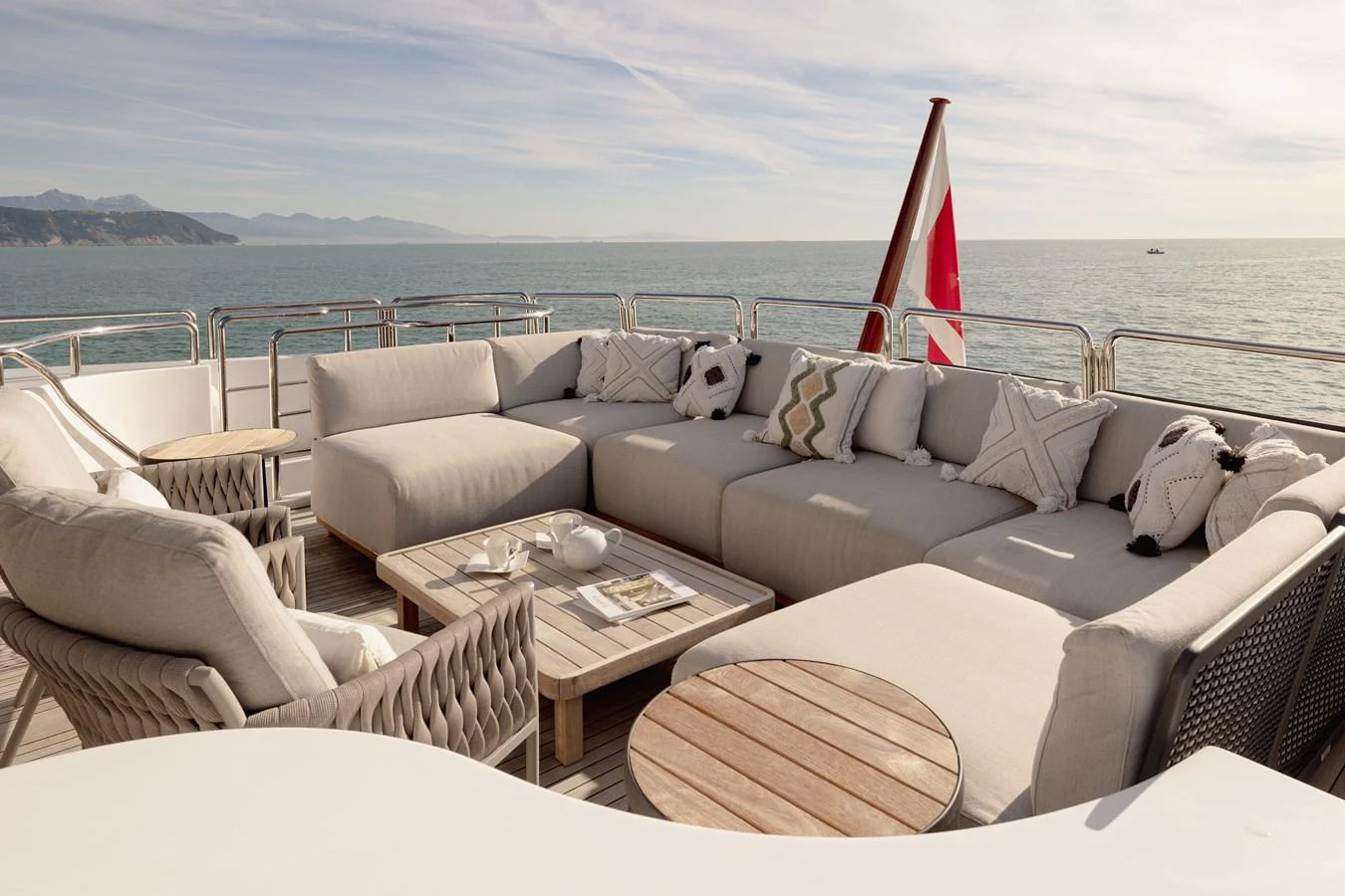 The aft deck features a luxurious outdoor lounge area with comfortable seating and stunning ocean views. aboard HOSHI Yacht for Sale