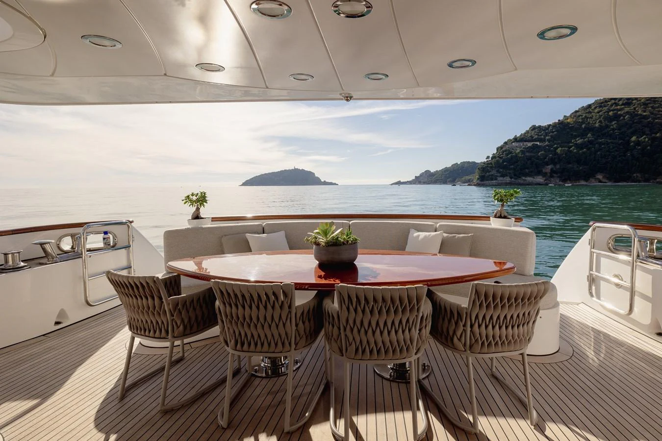 The aft deck features an elegant dining area with a stunning view of the sea. aboard HOSHI Yacht for Sale
