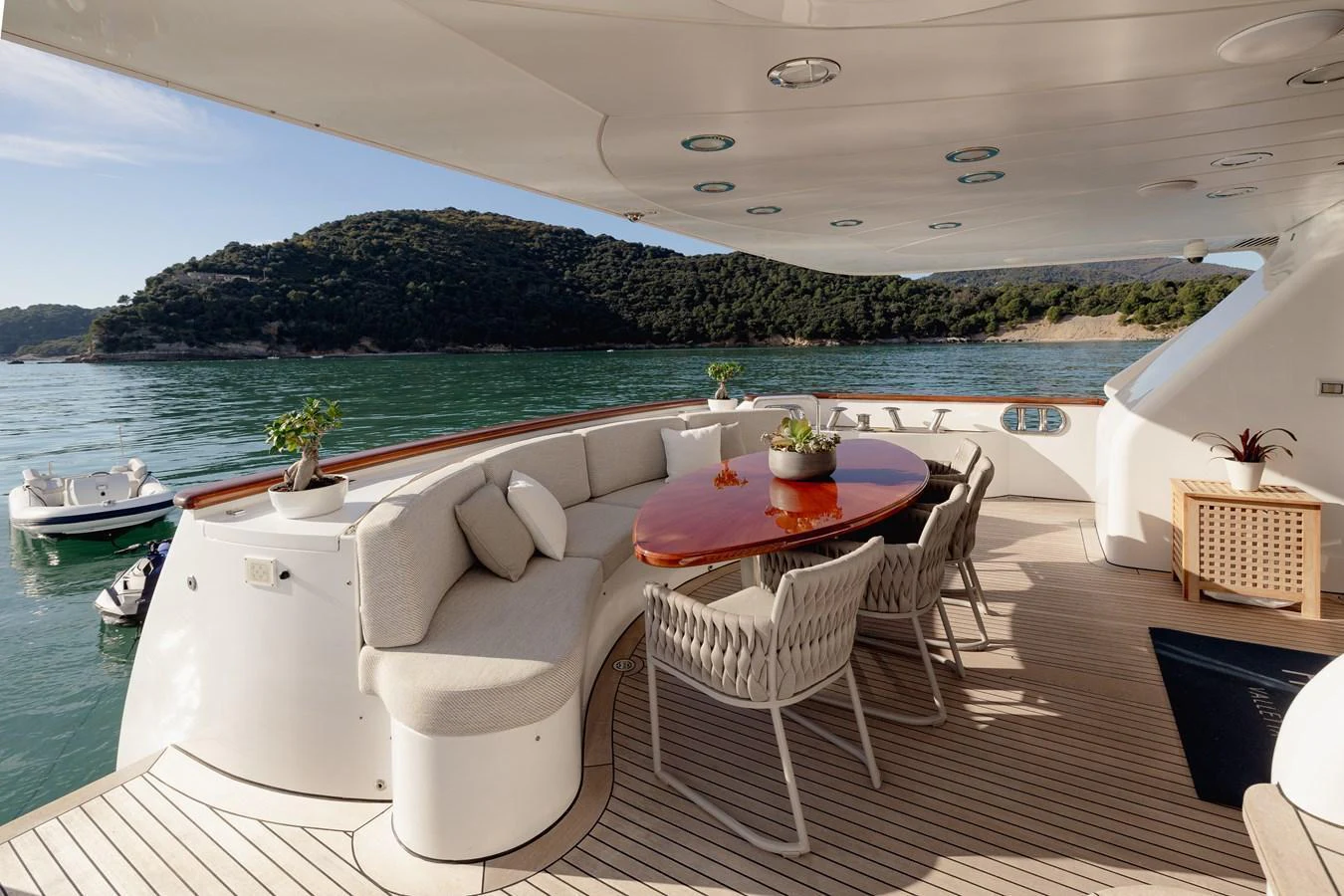 The aft deck features a stylish dining area with comfortable seating and scenic views. aboard HOSHI Yacht for Sale