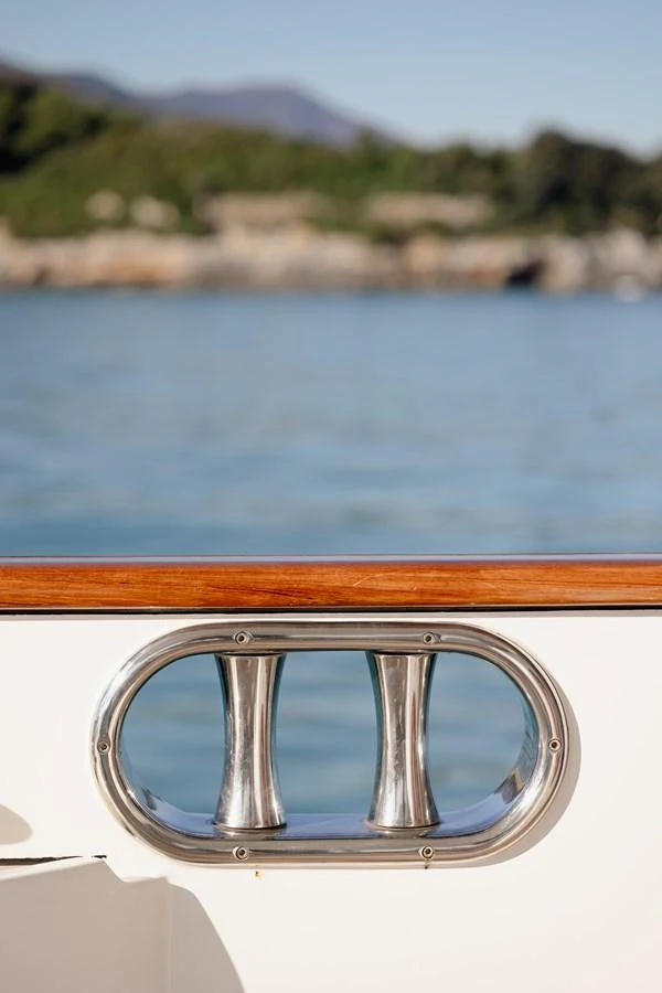 A polished stainless steel fairlead on the yacht's deck, with a scenic coastal background. aboard HOSHI Yacht for Sale