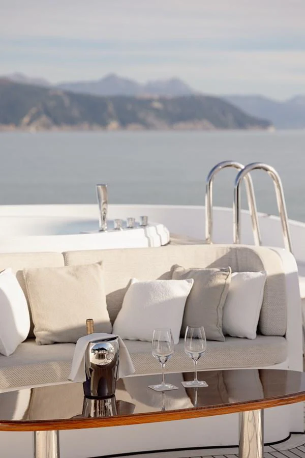 The sundeck features a cozy seating area with a coffee machine and wine glasses, perfect for relaxation. aboard HOSHI Yacht for Sale