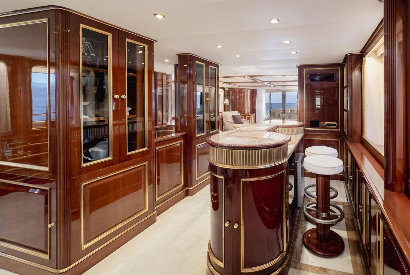 The yacht's interior features a luxurious bar area with elegant wood finishes and comfortable seating. aboard HOSHI Yacht for Sale