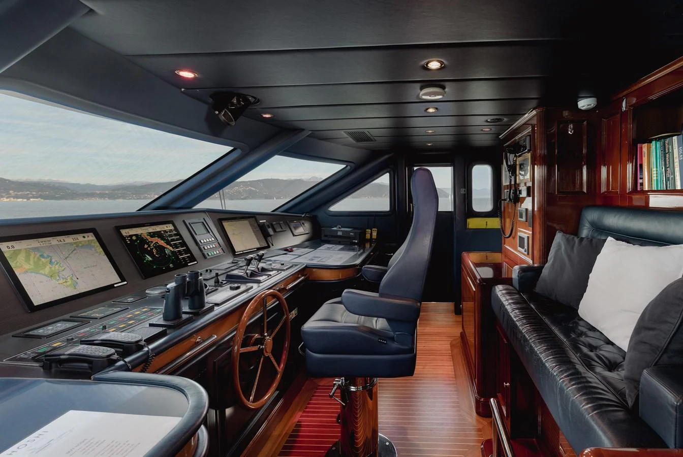 The helm station features advanced navigation equipment and a comfortable seating area with a panoramic view. aboard HOSHI Yacht for Sale