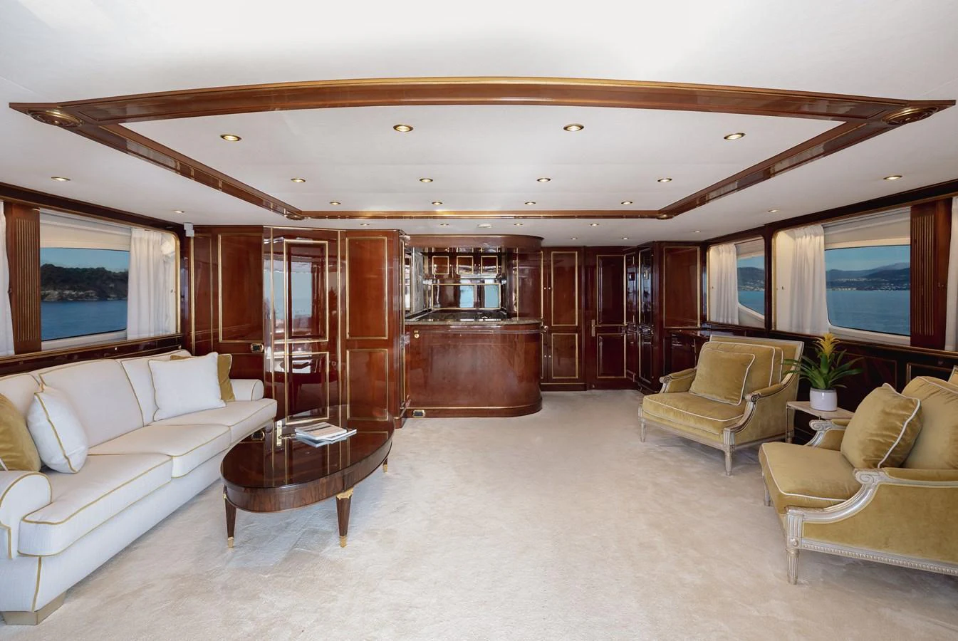 The salon features elegant wood paneling, plush seating, and large windows offering scenic views. aboard HOSHI Yacht for Sale