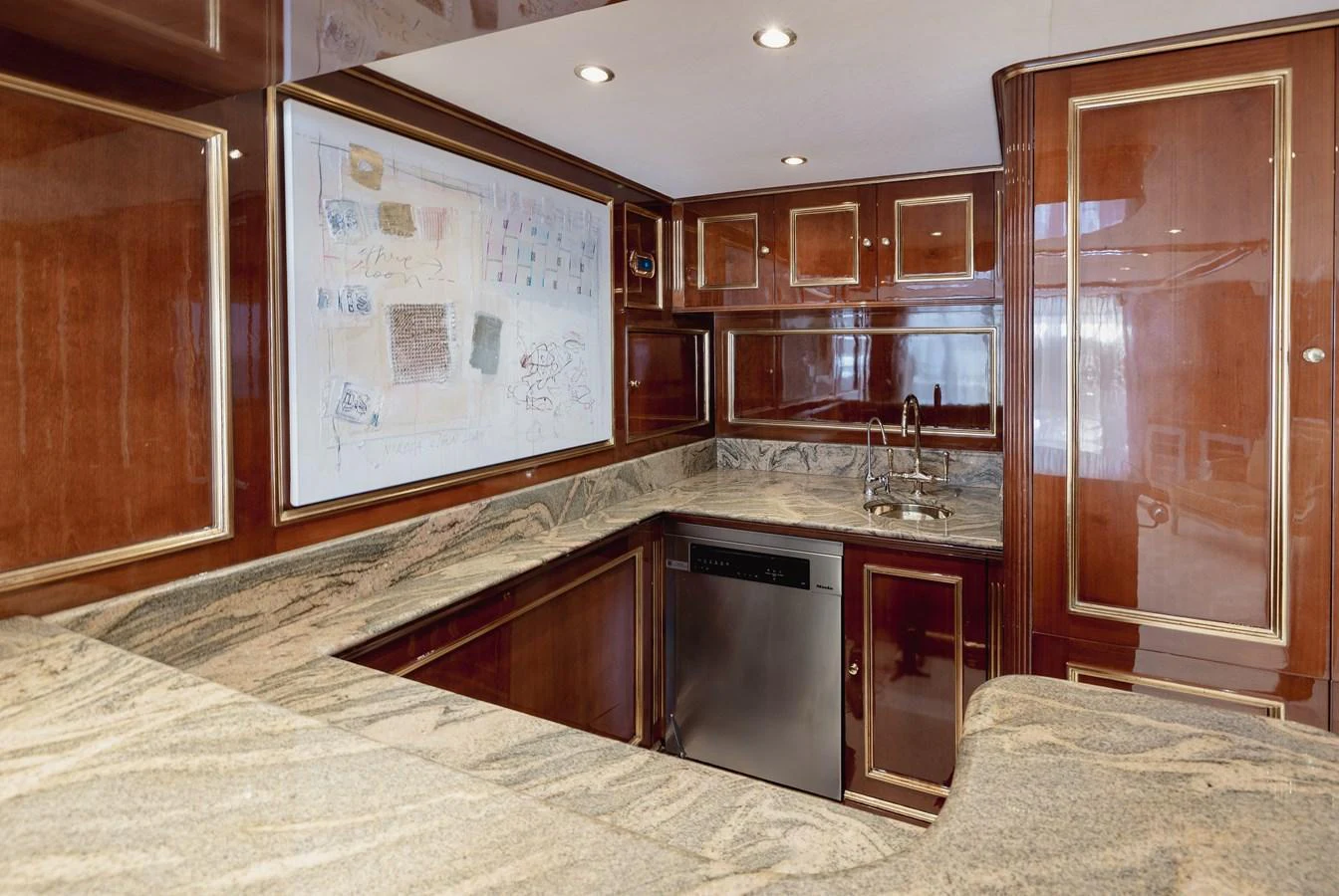 The yacht's galley features elegant wood paneling and modern appliances, creating a sophisticated culinary space. aboard HOSHI Yacht for Sale