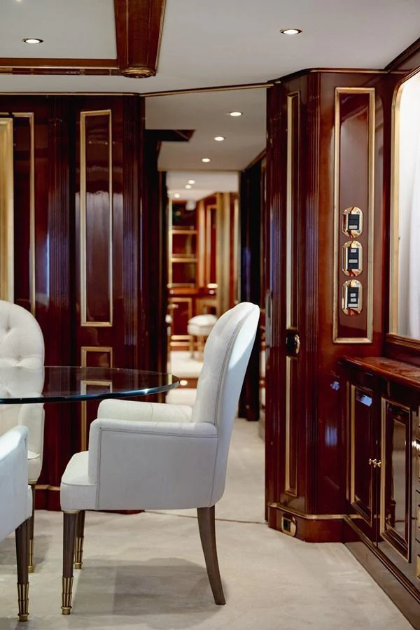 The yacht's interior features elegant wood paneling and plush seating, creating a luxurious and inviting atmosphere. aboard HOSHI Yacht for Sale