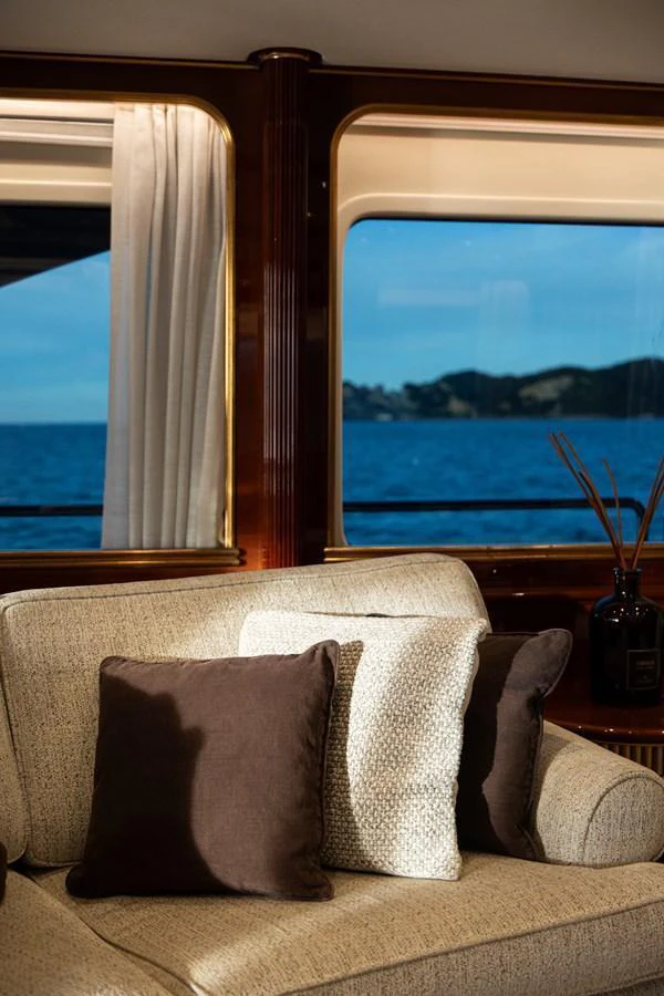 A cozy seating area with a view of the ocean through large windows. aboard HOSHI Yacht for Sale