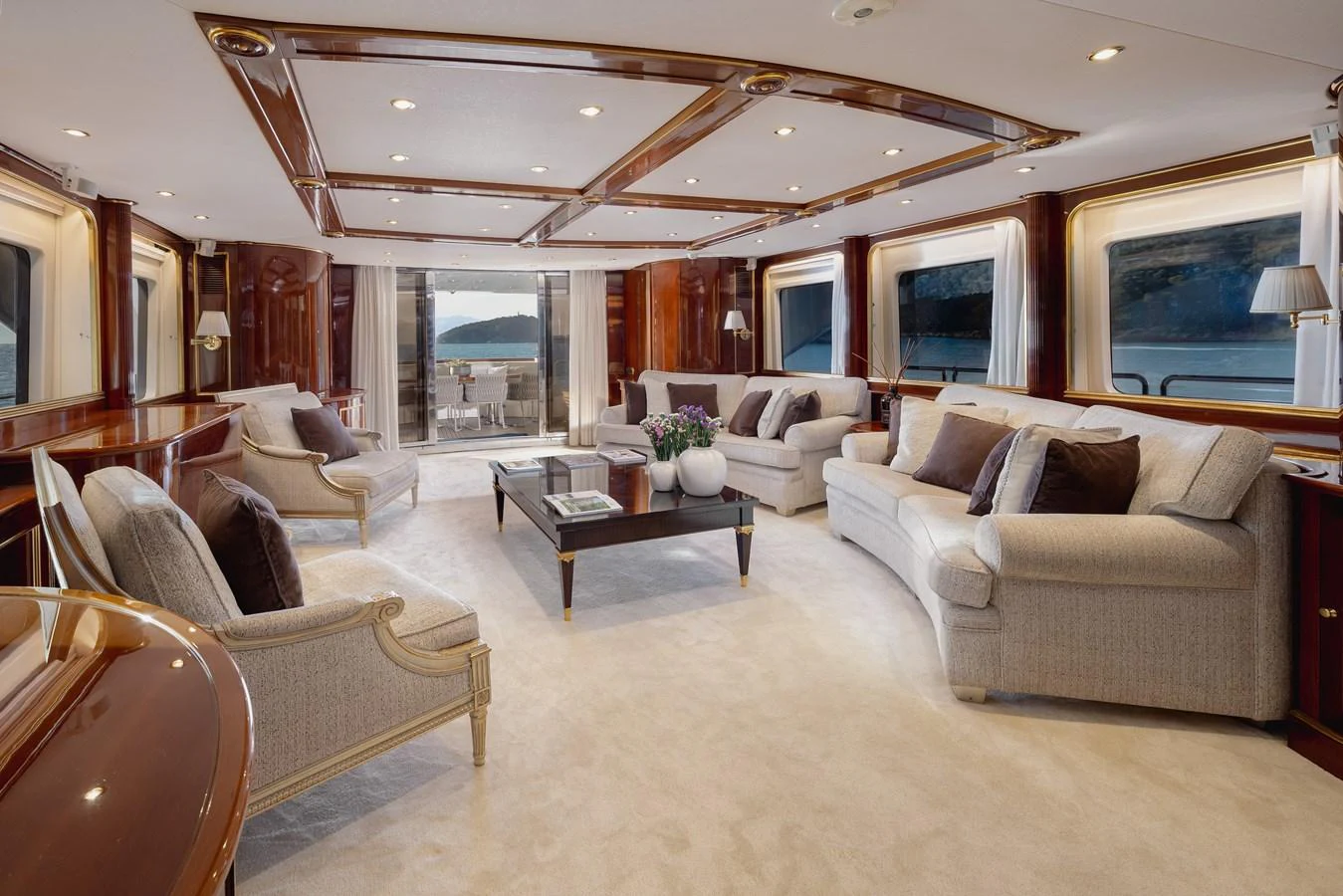 The salon offers a spacious and elegant setting with plush seating and panoramic views. aboard HOSHI Yacht for Sale