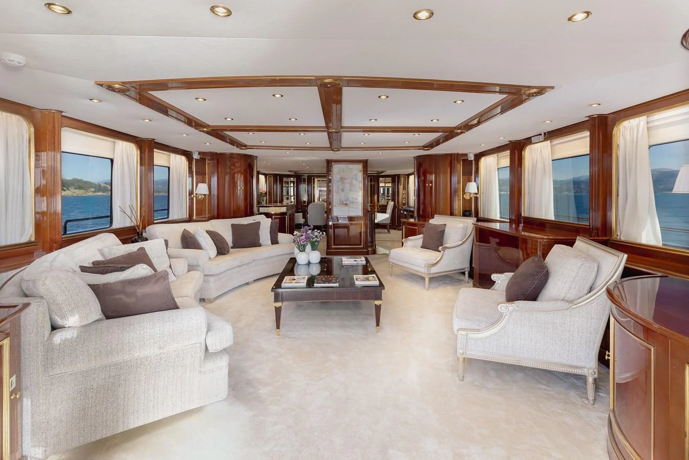 The spacious salon features elegant furnishings and large windows offering stunning sea views. aboard HOSHI Yacht for Sale