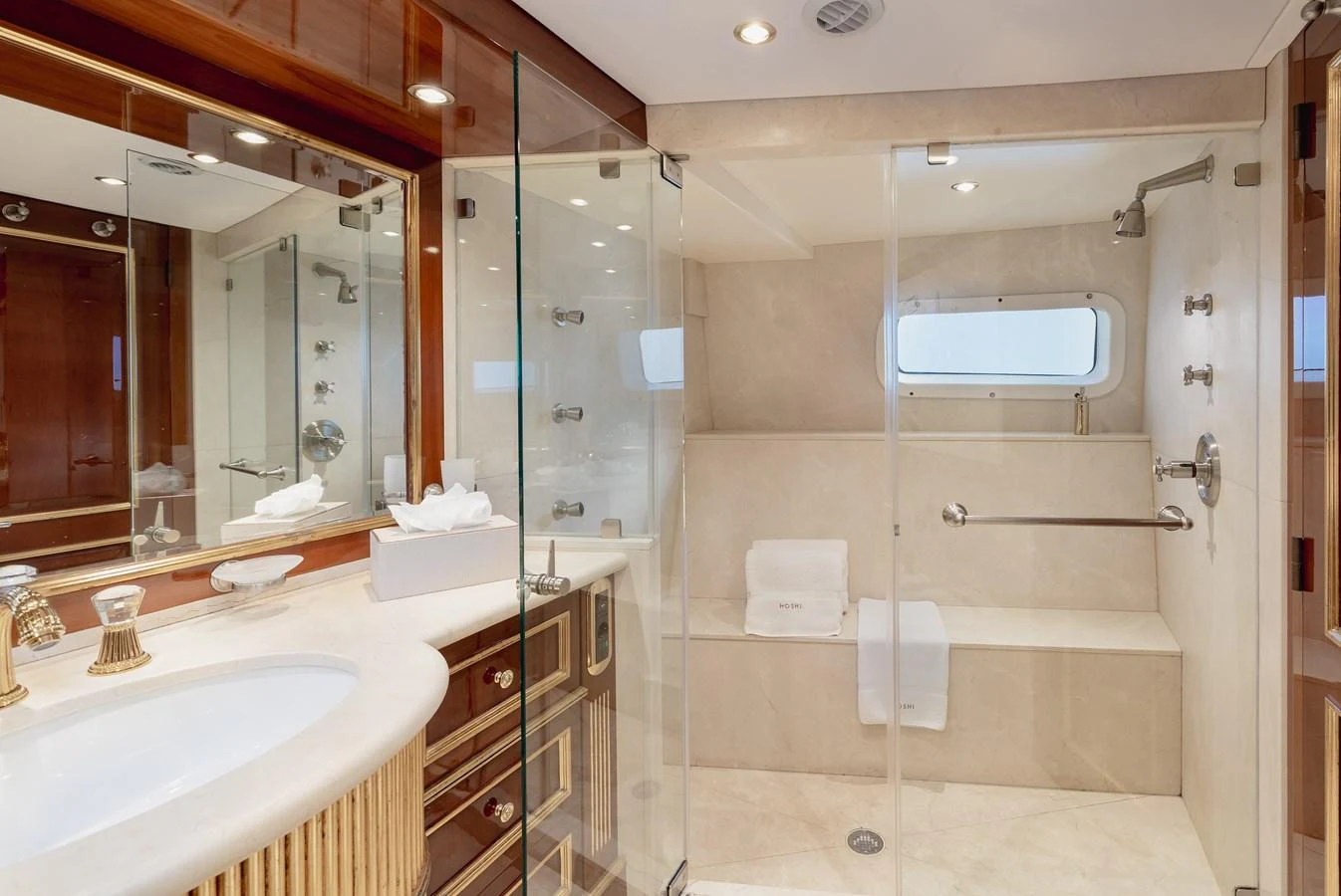The yacht's bathroom features a spacious shower area with elegant fixtures and a luxurious design. aboard HOSHI Yacht for Sale