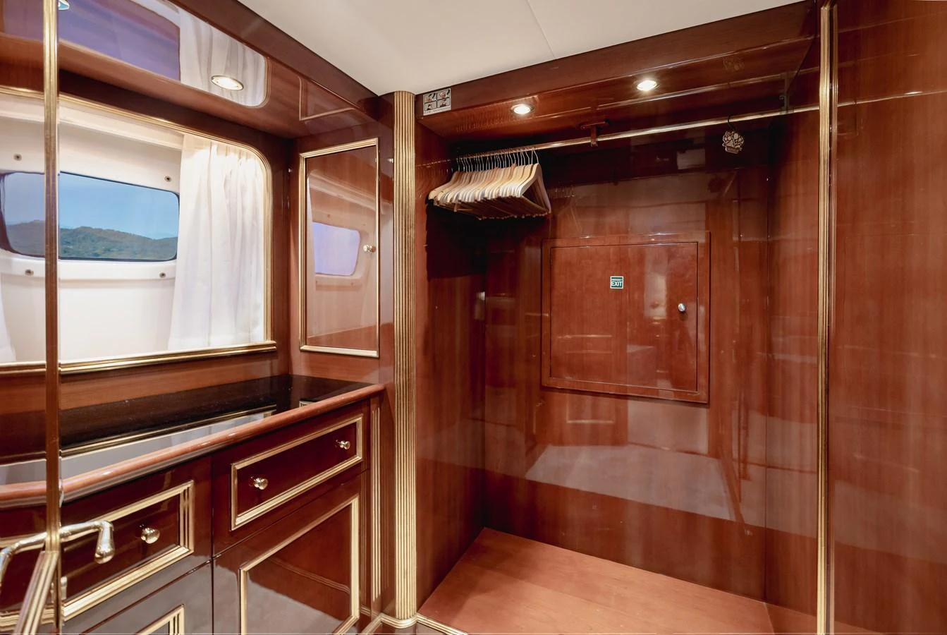 The yacht's interior features a luxurious wooden closet area with ample storage space and elegant lighting. aboard HOSHI Yacht for Sale