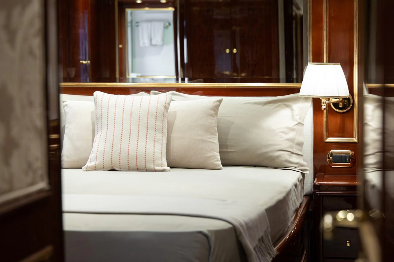 A cozy stateroom with elegant wooden finishes and soft lighting. aboard HOSHI Yacht for Sale