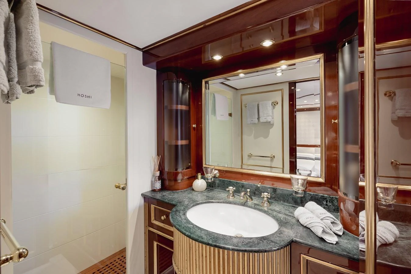 The yacht's bathroom features elegant wood accents and a luxurious marble countertop. aboard HOSHI Yacht for Sale