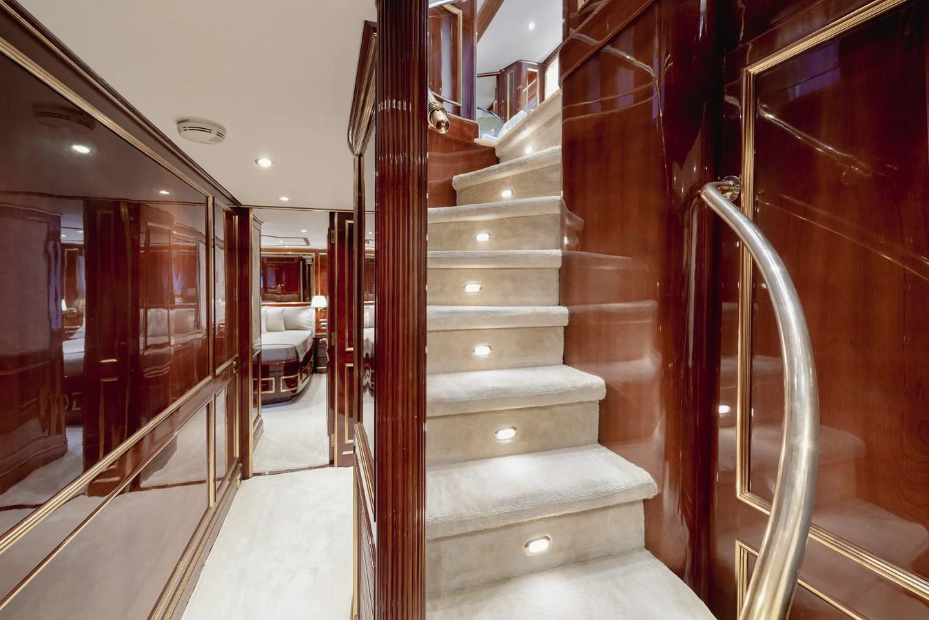 The yacht's interior features a luxurious staircase with plush carpeting and elegant wood paneling. aboard HOSHI Yacht for Sale