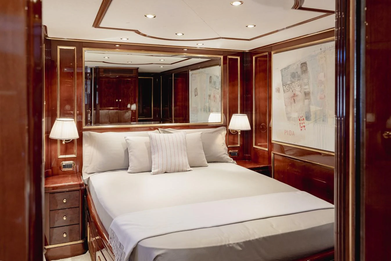 The stateroom exudes elegance with its polished wood finishes and luxurious bedding. aboard HOSHI Yacht for Sale