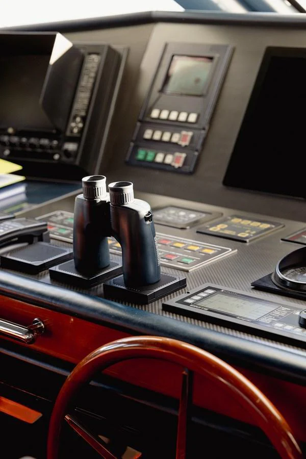 The helm station features advanced navigation equipment and a pair of binoculars for precise maritime control. aboard HOSHI Yacht for Sale