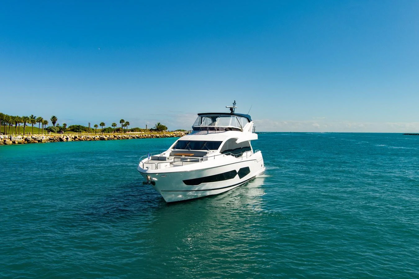 A sleek yacht cruises through clear blue waters under a bright sky. aboard MISTY K Yacht for Sale