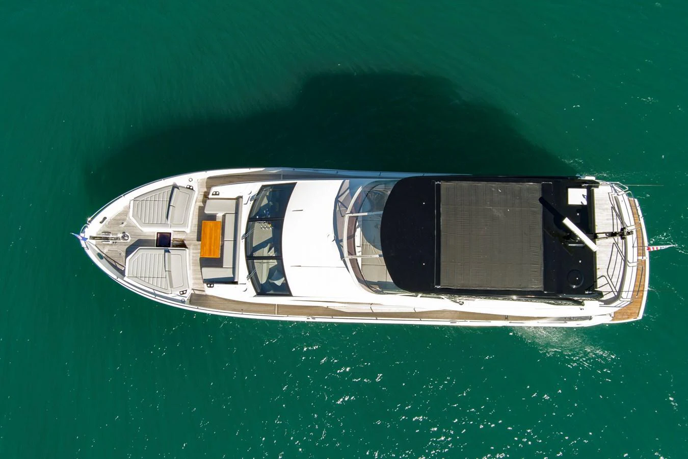 Aerial view of a sleek yacht cruising through clear, turquoise waters. aboard MISTY K Yacht for Sale