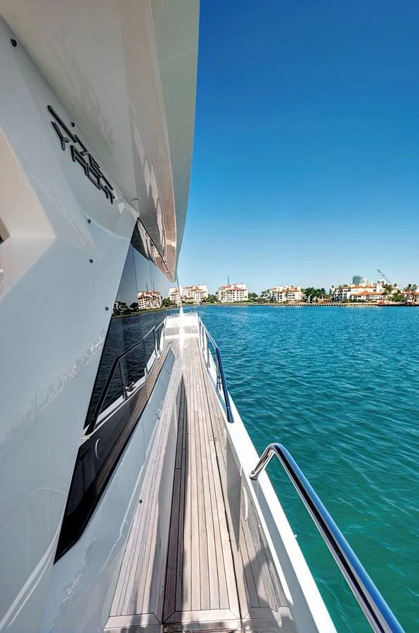 The yacht's side deck offers a stunning view of the surrounding waters and coastal homes. aboard MISTY K Yacht for Sale