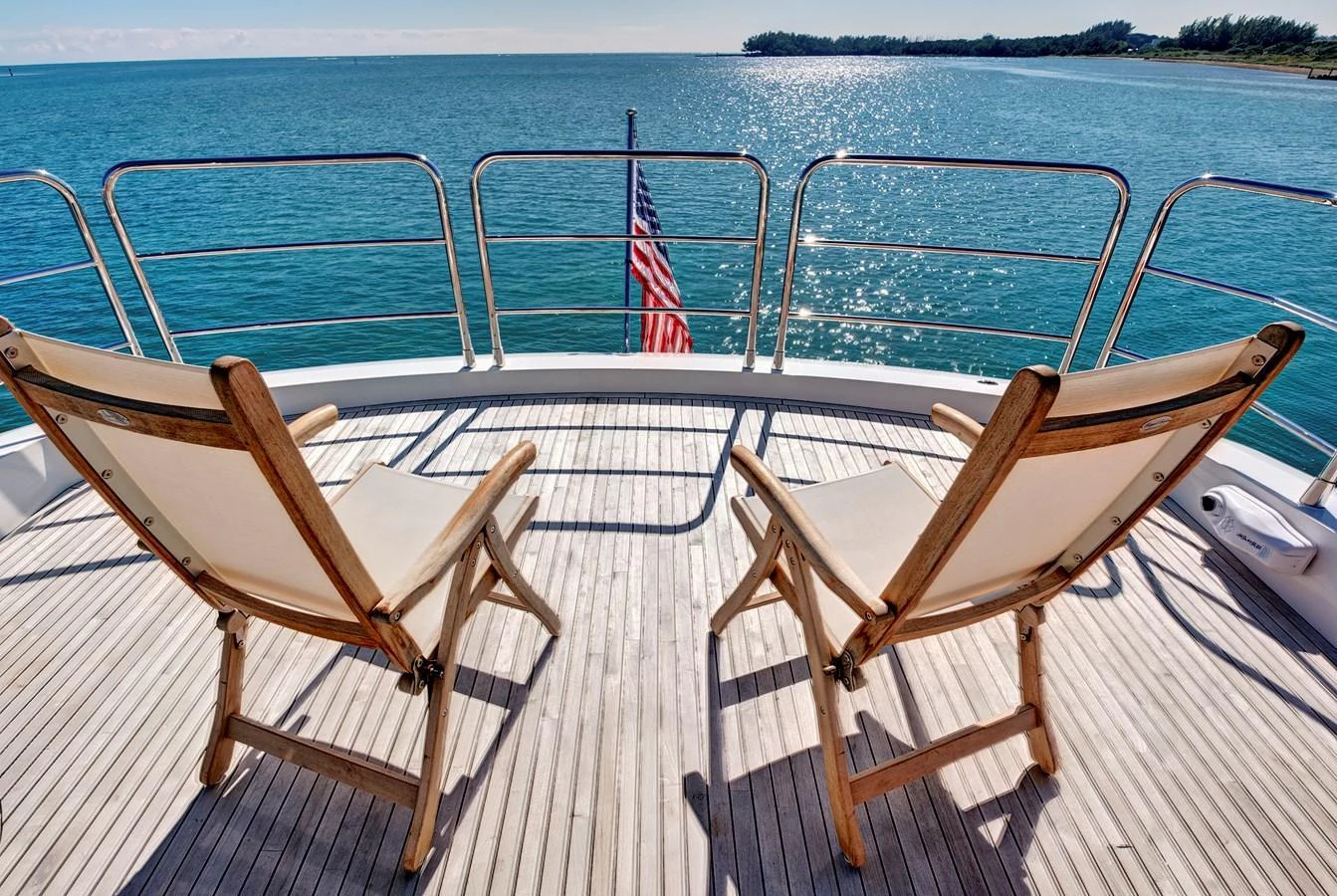 The aft deck offers a serene setting with two wooden lounge chairs overlooking the water. aboard MISTY K Yacht for Sale