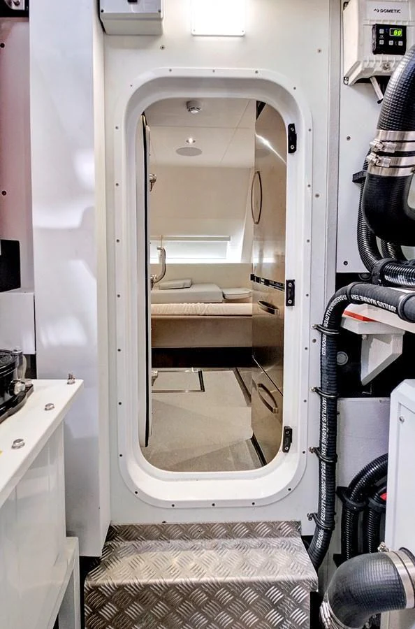 A view through a doorway into a cozy cabin with a bed and modern fixtures. aboard MISTY K Yacht for Sale