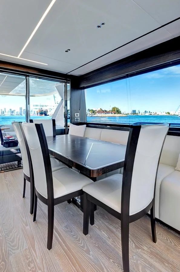 The yacht's dining area offers a stylish and comfortable space with a stunning view through large windows. aboard MISTY K Yacht for Sale
