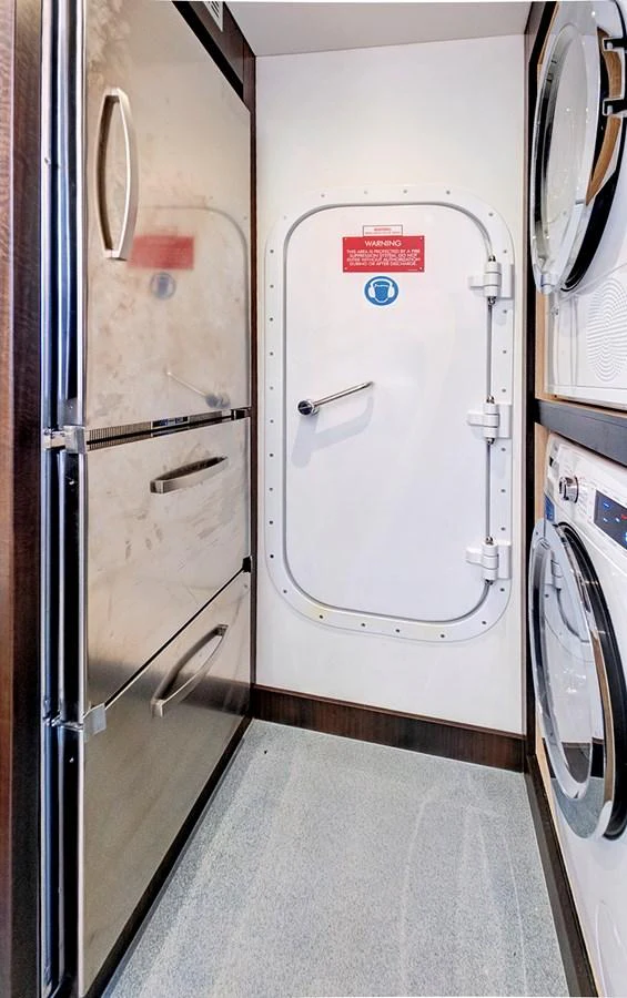 The yacht's laundry room features modern appliances and a secure door. aboard MISTY K Yacht for Sale