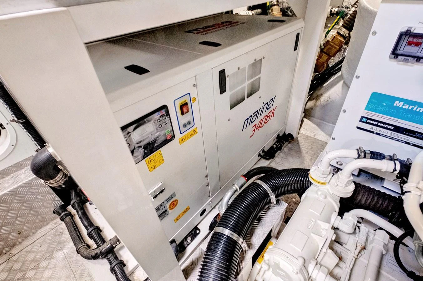 The image showcases the engine room with a focus on the generator and surrounding machinery. aboard MISTY K Yacht for Sale