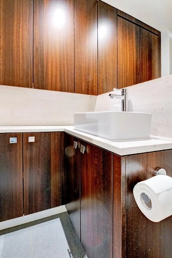 The yacht's bathroom features sleek wooden cabinetry and a modern sink. aboard MISTY K Yacht for Sale