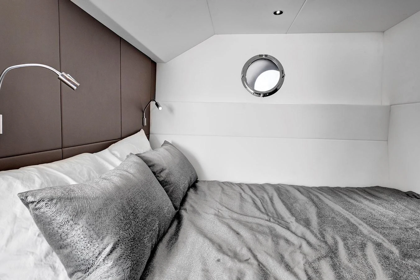 A cozy stateroom featuring a comfortable bed with plush pillows and modern reading lights. aboard MISTY K Yacht for Sale