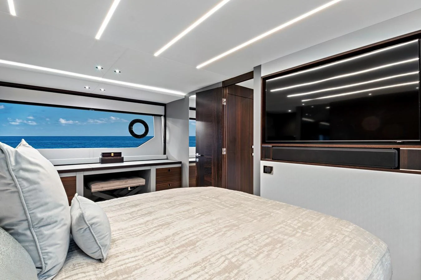 The stateroom features a luxurious bed, modern furnishings, and a large window with an ocean view. aboard MISTY K Yacht for Sale