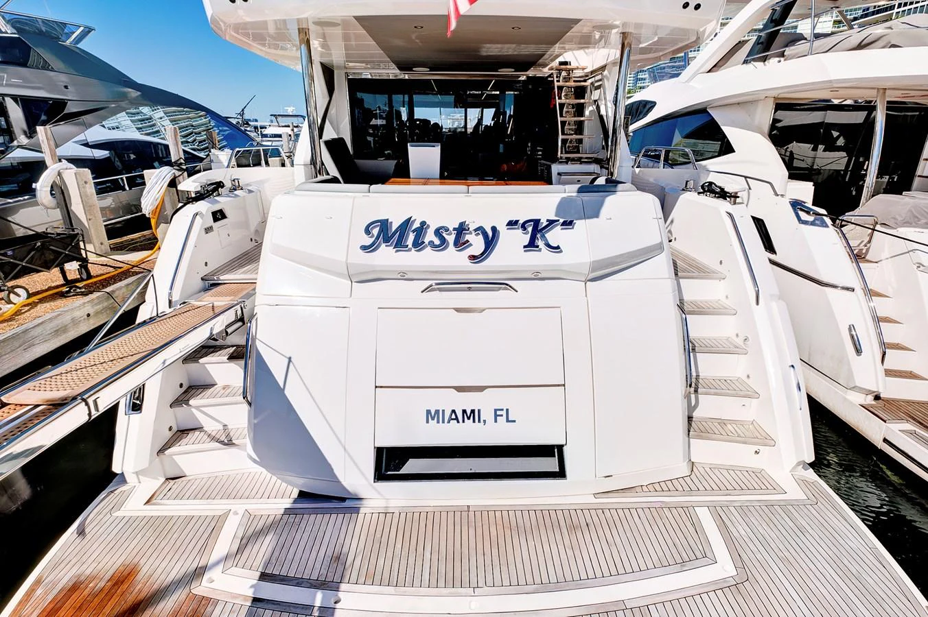 The aft deck of the yacht features a spacious and inviting layout with elegant stairs leading to the water. aboard MISTY K Yacht for Sale