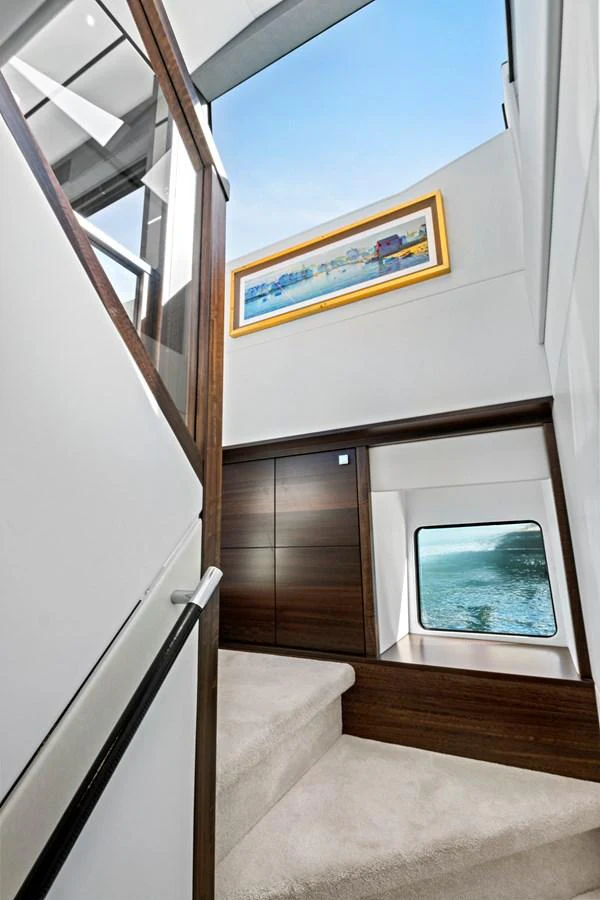 A modern yacht interior featuring a staircase with a window view of the sea. aboard MISTY K Yacht for Sale