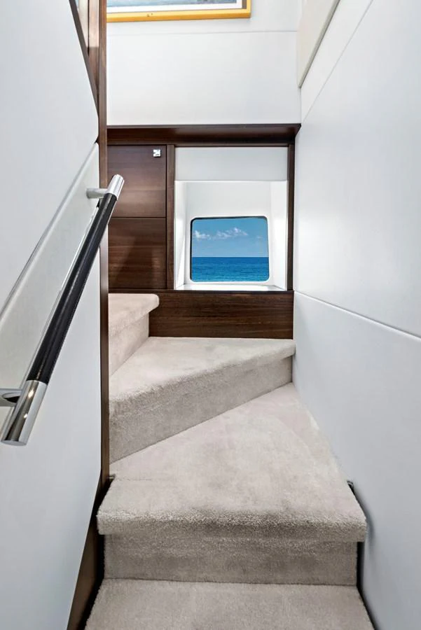 A well-lit staircase with a view of the ocean through a window. aboard MISTY K Yacht for Sale