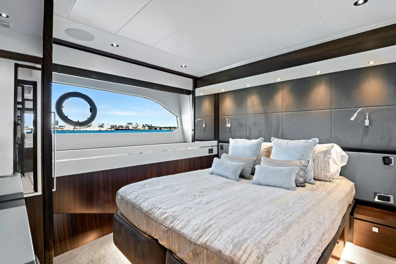 The stateroom features a plush bed with elegant bedding and a scenic view through the window. aboard MISTY K Yacht for Sale