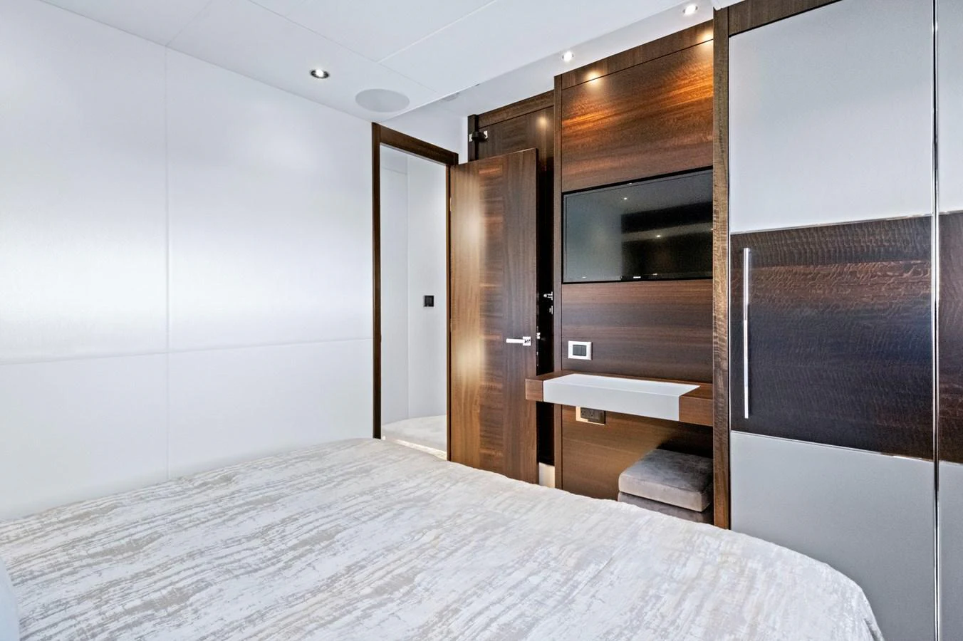 A modern stateroom featuring sleek wood finishes and a mounted flat-screen TV. aboard MISTY K Yacht for Sale