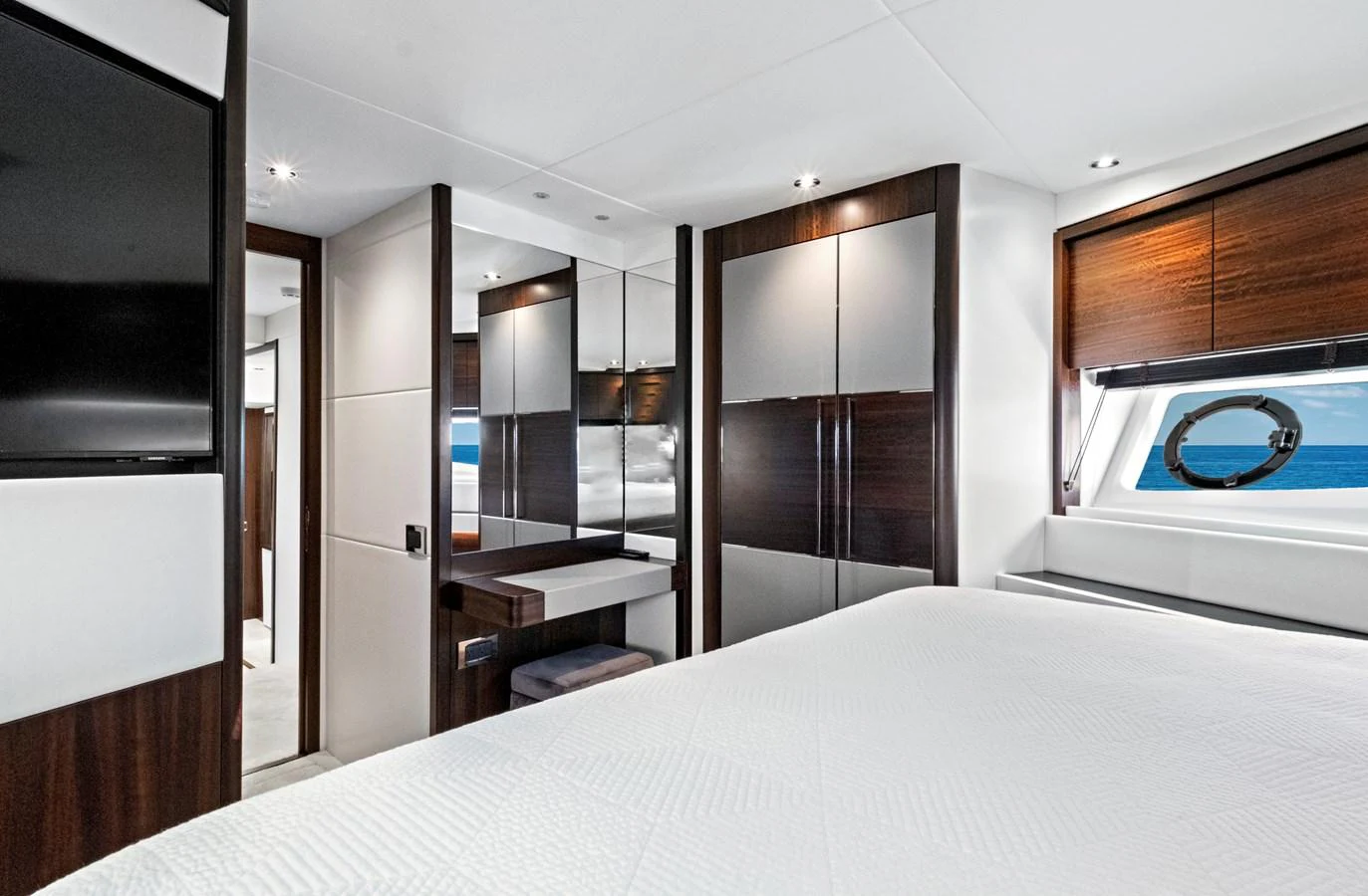 A luxurious stateroom featuring modern furnishings and a large window with an ocean view. aboard MISTY K Yacht for Sale