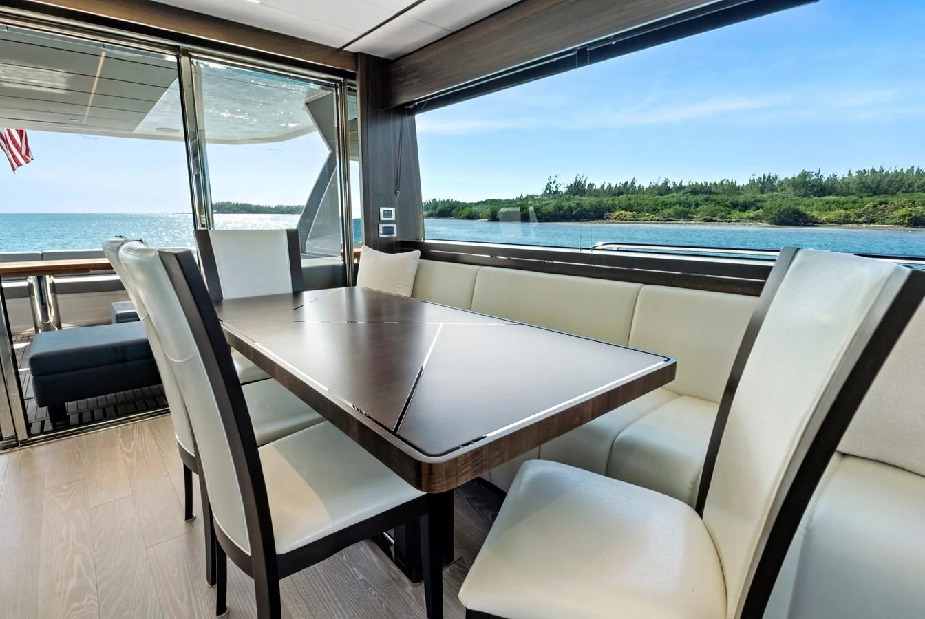 The yacht's dining area offers a luxurious and scenic setting with large windows overlooking the water. aboard MISTY K Yacht for Sale